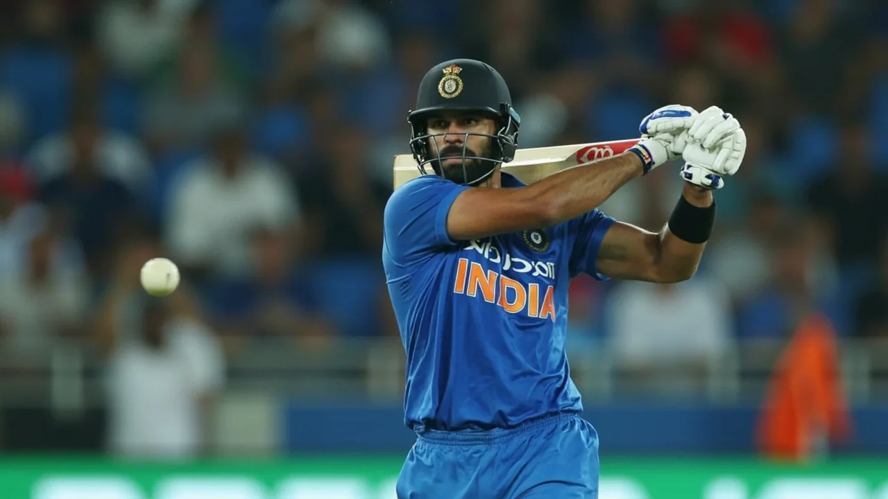 Tight sideline frame of an India batter in a white-ball batting stance at the crease with a fielder visible in the slip cordon